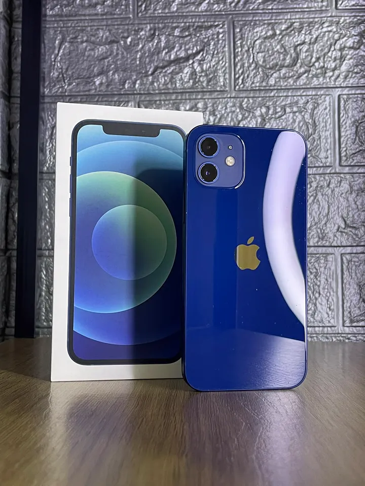 iPhone 12 azul em pé ao lado da caixa, na bancada da loja