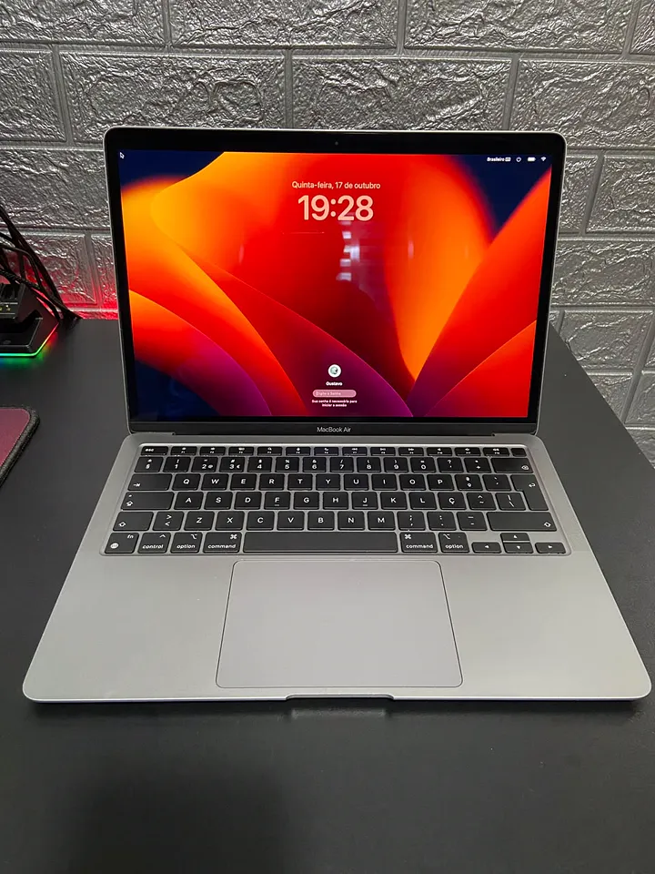 MacBook Air aberto e ligado na bancada da loja